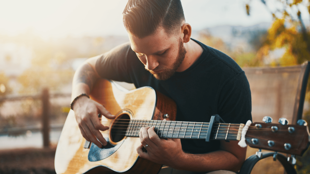A guitar player playing an acoustic guitar