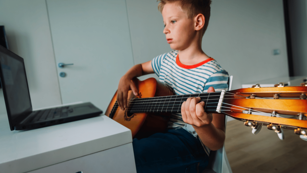 Young guitar player with laptop
