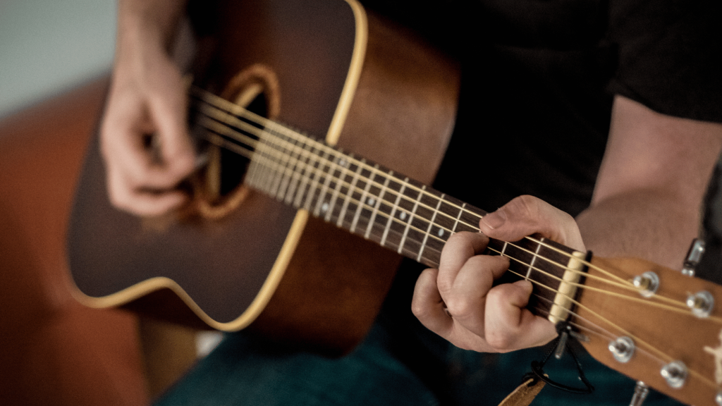 Acoustic guitar player playing a chord