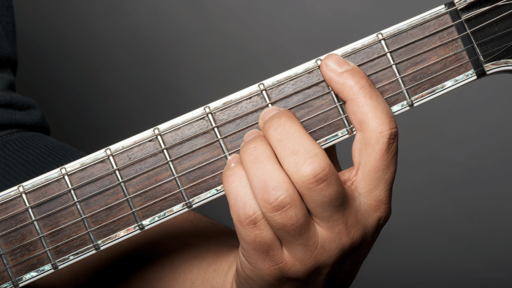 Guitar player playing a B major chord