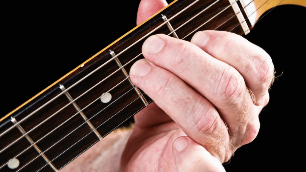 Guitar player playing the E major chord