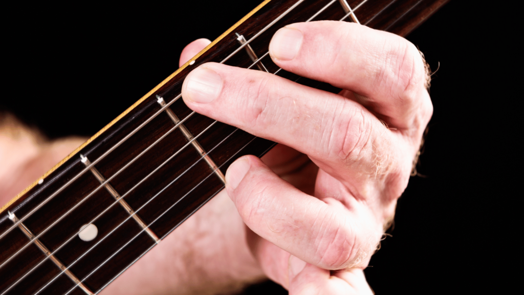 Guitar player playing a G major chord