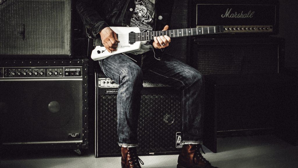 Guitar player sitting on an amplifier
