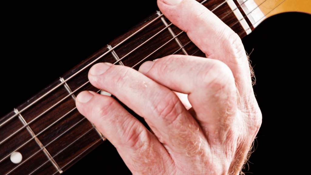 Guitar player playing an F major barre chord