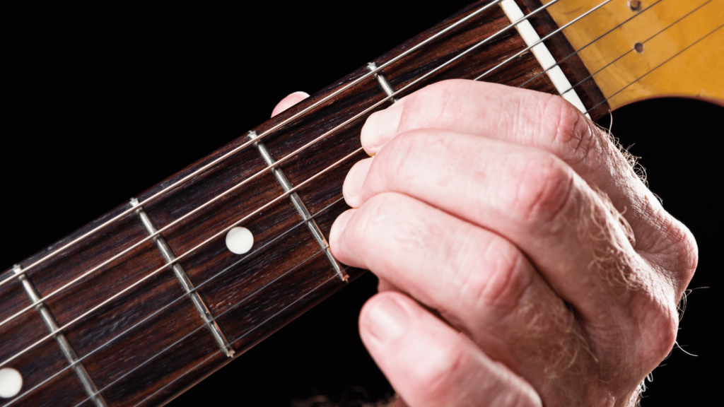 Guitar player playing an A Major chord