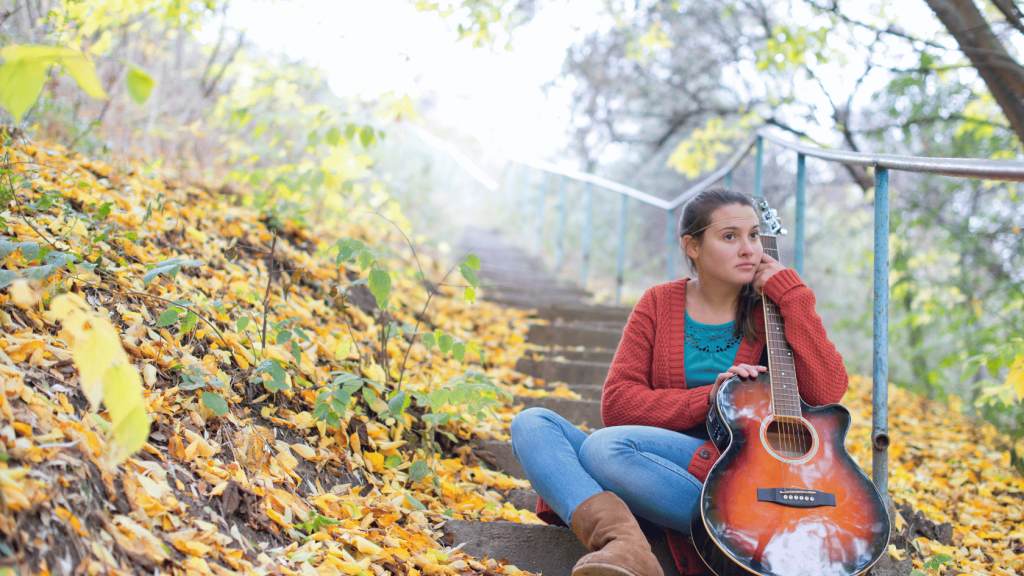 Guitar player outside holding a guitar