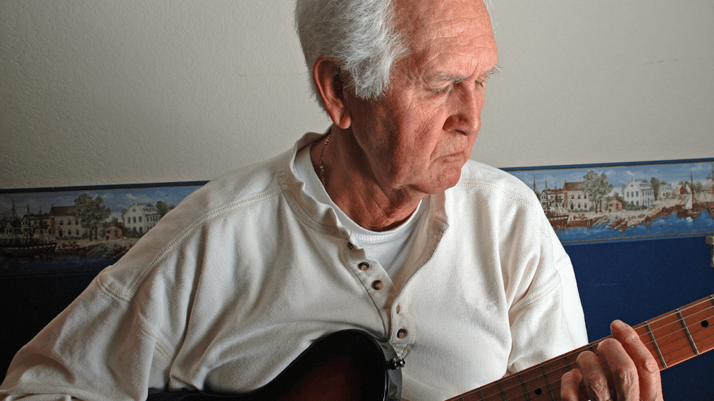 Senior adult playing electric guitar