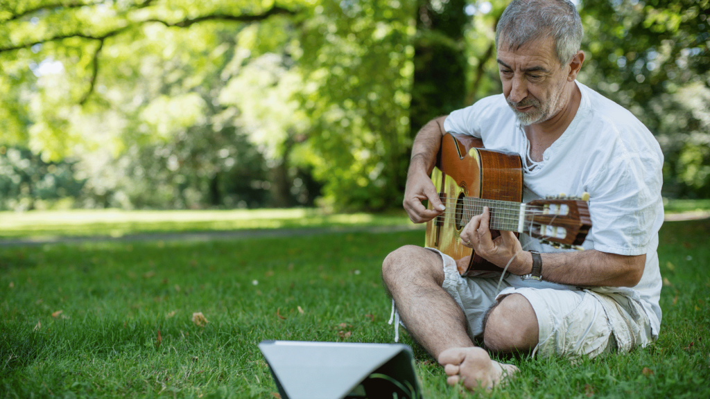 Senior practicing guitar with an app on an ipad

